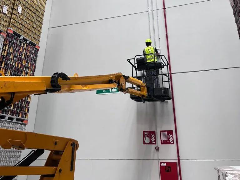 Technician working at height on a security installation